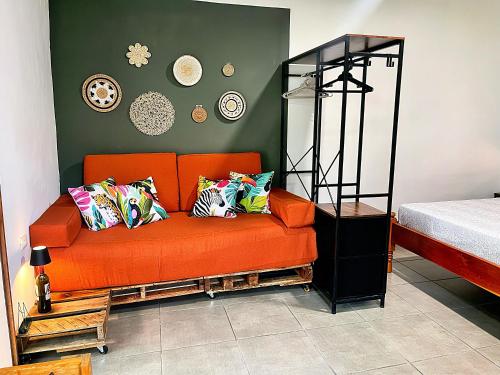 een oranje bank met kleurrijke kussens in een kamer bij Finca Aisa -Boutique bungalows in Ometepe island in Santa Cruz