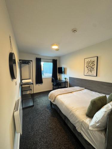 a bedroom with a bed and a chair in it at 248 Halls in Middlesbrough
