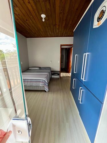 ein kleines Schlafzimmer mit einem Bett und einer Glastür in der Unterkunft Acomodação tranquila confortável 15 MT da praia in Florianópolis