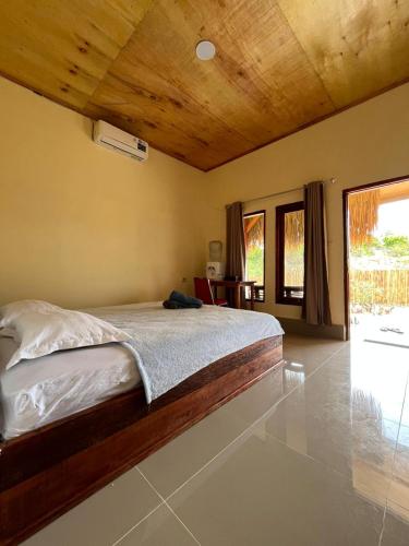 a bedroom with a bed with a wooden ceiling at Ekas Elen Homestay in Pulau Gilkaliantan