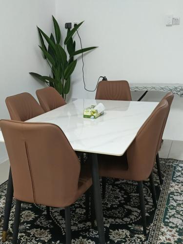 a white table with chairs and a plant at Inara Homestay in Kuala Lipis