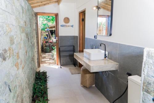 a bathroom with a sink and a stone wall at Mantra Yoga Homestay in Tanjung