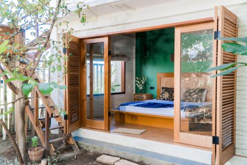 a room with a bed in a glass house at Mantra Yoga Homestay in Tanjung