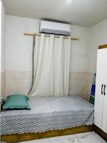 a small bed in a room with a curtain at Apartamento Completo e Centralizado 2 in Curro Velho