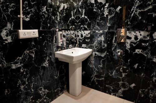 Baño en blanco y negro con lavabo en The Sweven Rishikesh, en Rishīkesh