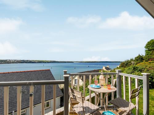 a balcony with a table and chairs and a view of the water at Haven View in Neyland