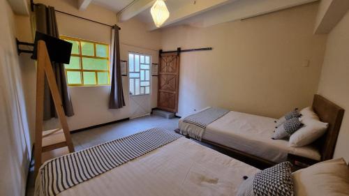 una habitación con dos camas y una ventana en Hotel Colonial Guanajuato, en Guanajuato