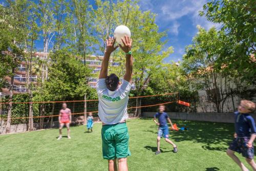 a young man reaching up to catch a frisbee at Aparthotel Cye Holiday Centre in Salou