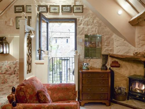 a living room with a chair and a fireplace at The Hayloft - Igp in Glaisdale