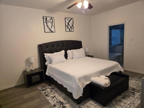 a bedroom with a large bed with a black headboard at Elegant family home in Cypress