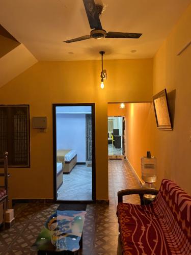 een woonkamer met een bank en een plafondventilator bij DSS HOME STAY Just 500 Meter Girivalam Road in Tiruvannamalai