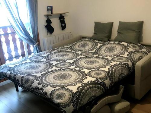 ein Bett mit einer Decke in einem Schlafzimmer in der Unterkunft Studio cosy à St Jean d'Aulps, au pied des pistes - FR-1-573-146 in Saint-Jean-dʼAulps