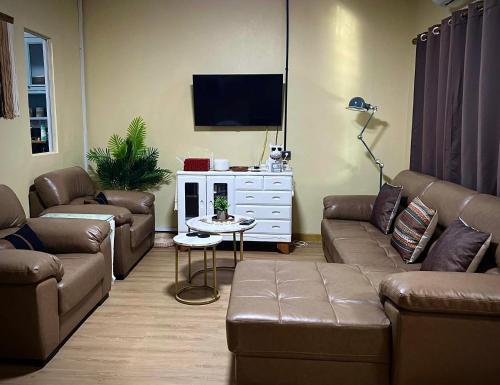 Una sala de estar con dos sofás y un televisor. en Casa Gris with Shared Pool, en Ban Bo Han