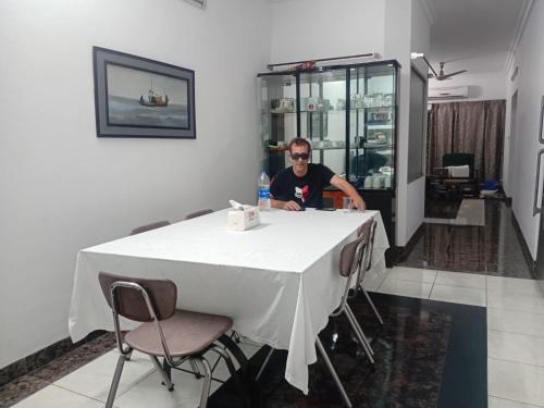 a man sitting at a table in a room at Maya Eco Guest House in Dhaka