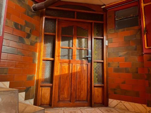 a wooden door on the side of a brick building at Altura View Stay in La Paz
