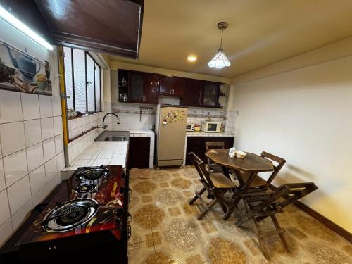 a kitchen with a stove and a table with chairs at Altura View Stay in La Paz