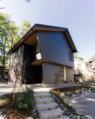a house with stairs in front of it at Kamuy Chalet Hakuba by Jade Villa in Hakuba