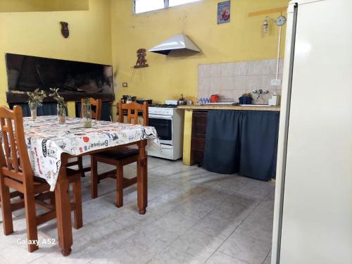 eine Küche mit einem Tisch mit Stühlen und einem Herd in der Unterkunft Depto en arrecifes in Arrecifes