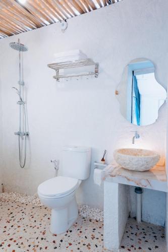 a white bathroom with a toilet and a sink at HappyNest Glamping and Villa Dieng in Garung