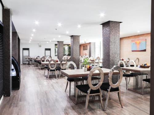 a dining room with tables and chairs in a restaurant at Jomtien Sands Residence - Beachfront, Relax & Amazing Seafood Dining in Jomtien Beach