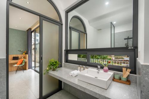 a bathroom with a sink and a mirror at BQ Manor by Class6 in Danang