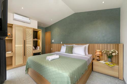 a bedroom with a large bed with a green blanket at BQ Manor by Class6 in Danang