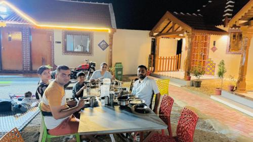 a group of people sitting at a table in a restaurant at Holiday Homestay dholavira 