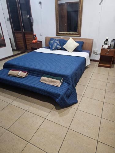 a bedroom with a blue bed with two towels on it at Barret Lodge in Suva