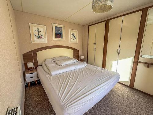 Schlafzimmer mit einem großen weißen Bett in der Unterkunft Beautiful 6 Berth Caravan For Hire With Huge Decking At Manor Park Ref 23142K in Hunstanton