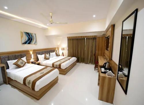 Una habitación de hotel con dos camas y un televisor. en Hotel Sunshine At Delhi Airport, en Dwarka, Nueva Delhi