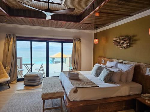 Un dormitorio con una cama con vista al mar. en La Digue Luxury Beach Resort & Spa, en La Digue
