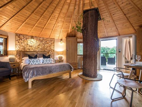 a bedroom with a bed and a tree in it at Bensfield Treehouse in Wadhurst