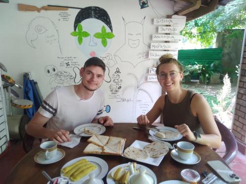 a man and a woman sitting at a table with food at Sigiriya Lions Rest Hostel in Sigiriya