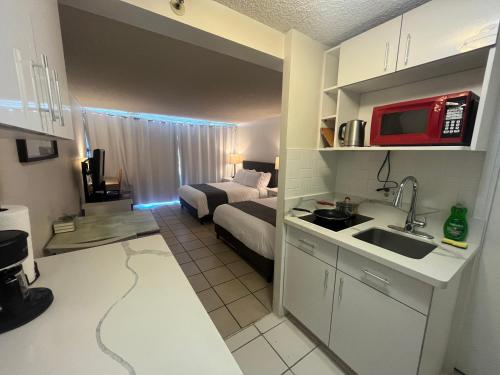 une chambre avec un lit et une cuisine avec un évier dans l'établissement A Homie Getaway! Double Bed Studio with a VIEW, à Honolulu