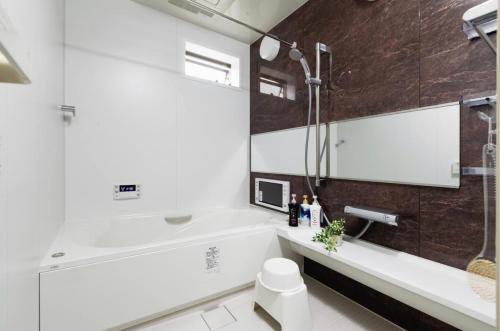 un baño con bañera y lavabo en 临近京瓷大阪巨蛋大正地铁站jr环状线站全新別墅, en Wada