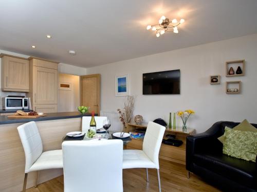 a kitchen and living room with a table and chairs at 1 Harbour View in Newquay