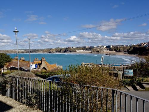 a view of a beach with a fence and water at 1 Harbour View in Newquay