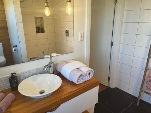ein Badezimmer mit Waschbecken und Spiegel in der Unterkunft Cable Bay Seaview Beauty in Cable Bay