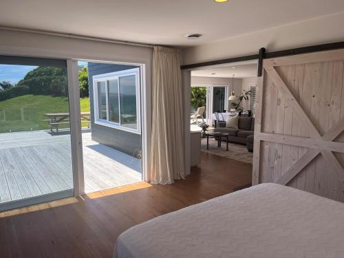 ein Schlafzimmer mit Schiebetür und ein Wohnzimmer in der Unterkunft Cable Bay Seaview Beauty in Cable Bay