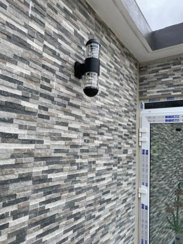 a bathroom with a light on a brick wall at Anne's Emerald Tranquility Villas in Laborie