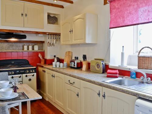 a kitchen with white cabinets and a sink at The School House - 28445 in Middleton in Teesdale