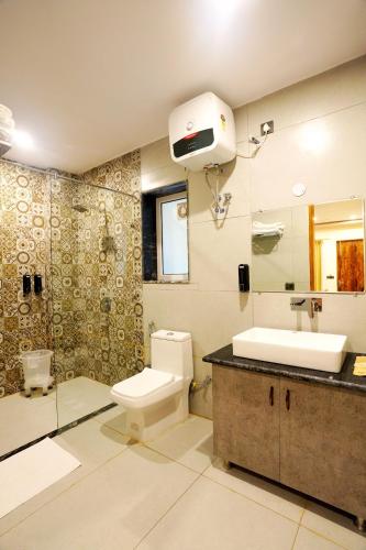 a bathroom with a toilet and a sink at MVT Guesthouse & Restaurant (Rishikesh) in Rishīkesh