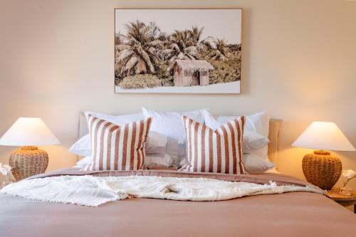 a bedroom with a bed with two lamps at Pure Indulgence in Merimbula