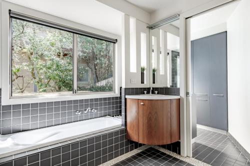 a bathroom with a tub and a sink and a window at Pure Indulgence in Merimbula