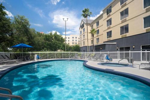 a large swimming pool with chairs and a building at Fairfield Inn Orlando Airport in Orlando
