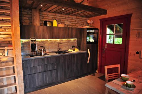 eine Küche mit einem Waschbecken und einem Tisch in einer Hütte in der Unterkunft Blockhaus Bodefall in Braunlage