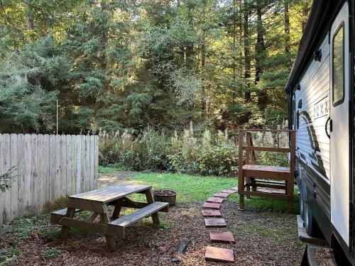 a picnic table and a bench next to a fence at Puma The RV in Klamath