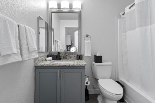 ein Badezimmer mit Waschbecken, Toilette und Spiegel in der Unterkunft Modern Tempe Retreat Near ASU & Downtown in Tempe