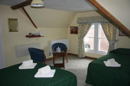 a living room with two beds and a window at Yarn Market Hotel in Dunster
