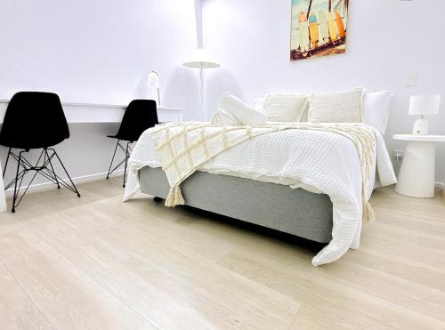 una camera con un letto e due sedie nere di City Oasis - Free Parking Gym Beach Pool - Sleep 6 a Brisbane